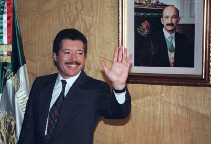 Luis Donaldo Colosio, frente a bandera mexicana.