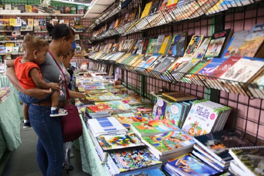 Mujer observa libros en la Feria del Libro 2019.