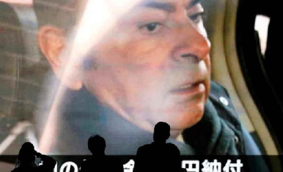 Peatones pasan delante de pantalla que muestra al expresidente de Nissan Motor Carlos Ghosn, en Tokio, (Fuente EFE).