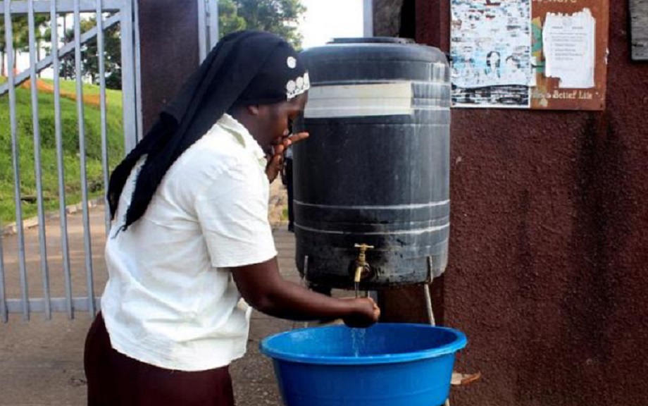 Una mujer local se lava las manos con agua con cloro antes de ingresar al Hospital General de Bwera, (Fuente EFE).