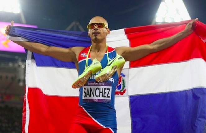 Félix 'Súper' Sánchez, exatleta olímpico, exhibe bandera dominicana.