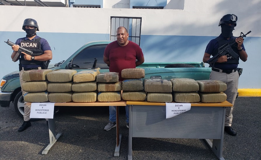 Autoridades presentan a José Miguel Comas Martínez (El Gordo) y las pacas de marihuana incautadas. (Foto externa)