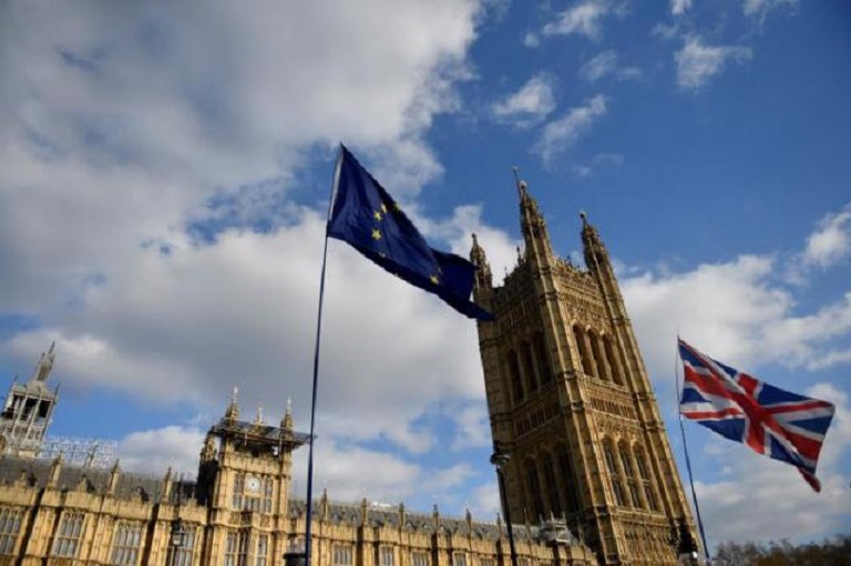 Las banderas del Reino Unido y la Unión Europea ondean a las puertas del Parlamento en Westminster. (Foto EFE/Neil Hall)