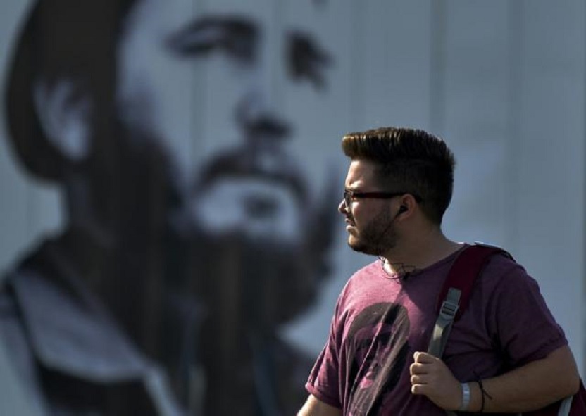 Un hombre con barba pasa cerca de un mural con la imagen del líder de la revolución cubana Fidel Castro.