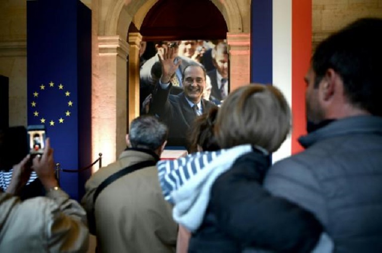 Varias personas ante el féretro del expresidente francés Jacques Chirac, instalado en los Inválidos de París para un homenaje popular el 29 de septiembre de 2019. (Foto AFP)