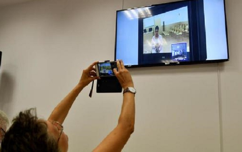 Una periodista fotografía la pantalla en la que se ve la declaración de la hija de Ana Julia Quezada. (Foto EFE)