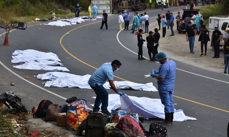 Forenses cubriendo los cadáveres de pasajeros que murieron en una colisión entre un autobús y un camión de carga.(Foto Carlos Cruz AP)