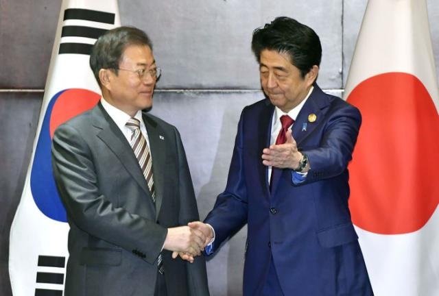 El Primer Ministro de Japón, Shinzo Abe, da la mano al Presidente de Corea del Sur, Moon Jae-in, durante su reunión en Chengdu, China.(Foto externa)