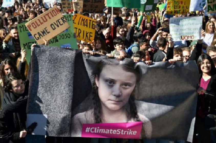 Jóvenes manifestantes sostienen una fotografía de la activista sueca Greta Thunberg durante una protesta contra el cambio climático y el calentamiento global el 15 de marzo de 2019 en el centro de Roma.