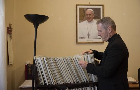 Monseñor John Kennedy, director del tribunal de la Congregación de la Doctrina de la Fe del Vaticano, revisa archivos en su oficina.(Foto AP /Alessandra Tarantino)