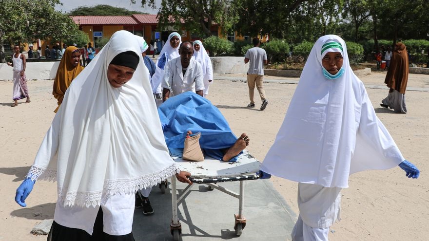 Personas cagando los muertos y heridos en ataque suicida en Somalia.(Foto: AP)