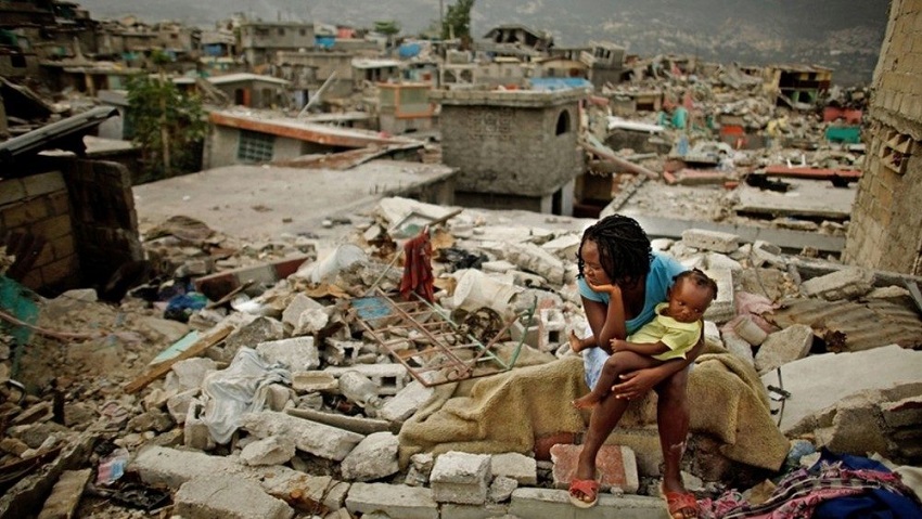 Una haitiana con una bebe en brazos en medio de la destrucción del terremoto de Haití.(foto: externa)