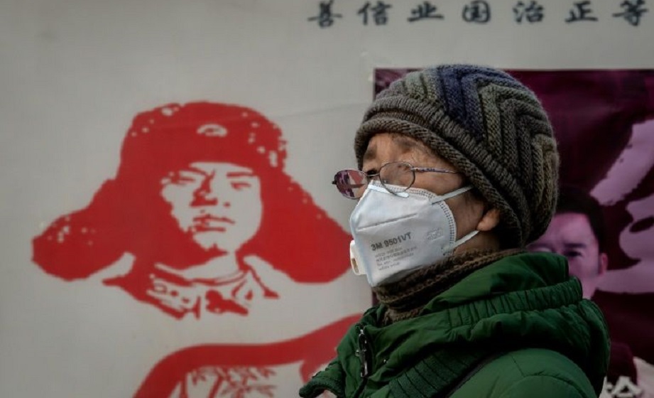 Una mujer con mascarilla de protección contra la epidemia de coronavirus, cerca de la estación de trenes de Pekín.