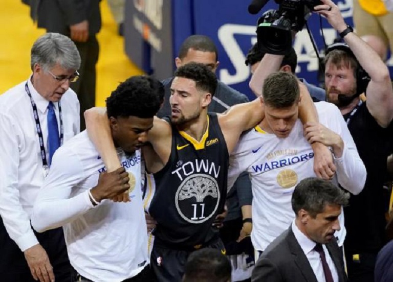 Klay Thompson (c), tras salir de juego ayudado por compañeros. (Foto: EFE/John G. Mablango)