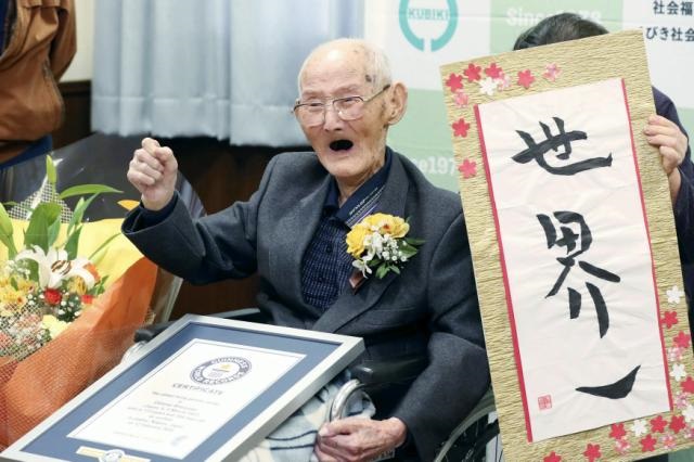 Chitetsu Watanabe, de 112 años, posa junto a un cartel que escribió tras ser condecorado como el hombre más viejo del mundo por el Guinness World Records, en Joetsu, en la prefectura de Niigata, en el norte de Japón, el 12 de febrero de 2020. (Foto: Kyodo News / AP)