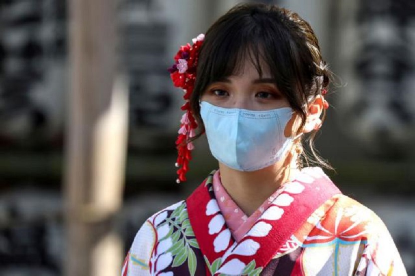 Una mujer con un kimono y una máscara facial protectora visita el Templo Sensoji en el distrito de Asakusa en Tokio, Japón.