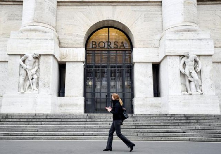 Una mujer pasa por la Bolsa Italiana de Milán, Italia.
