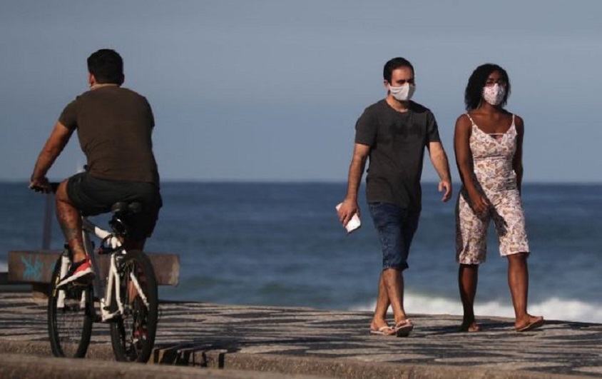 Una pareja camina junto a la playa de Leblon, en medio del brote de coronavirus en Río de Janeiro. Brasil. (Fuente: Reuters)
