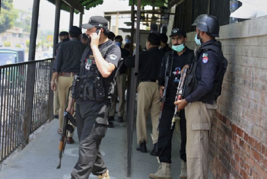 Policías reunidos en un acceso a la corte del distrito tras el asesinato de Tahir Shamim Ahmad, Pakistán. (Fuente: Muhammad Sajjad/AP)