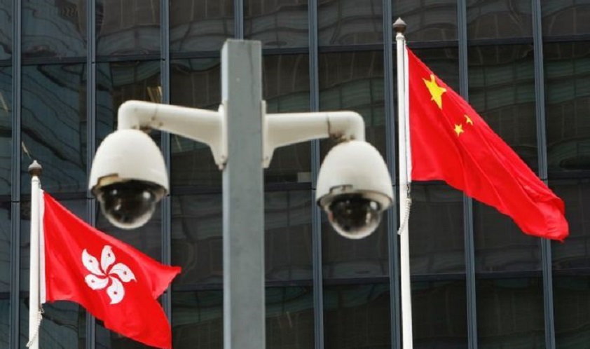 Las banderas nacionales de Hong Kong y China ondean detrás de un par de cámaras.