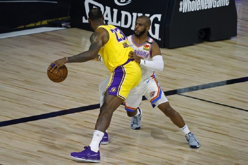 LeBron James (23) de Los Angeles Lakers es defendido por Chris Paul del Oklahoma City Thunder.