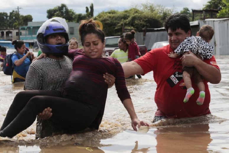Una mujer embarazada es evacuada en brazos de una zona inundada por el huracán Eta en Honduras. (Fuente: Delmer Martinez / AP)