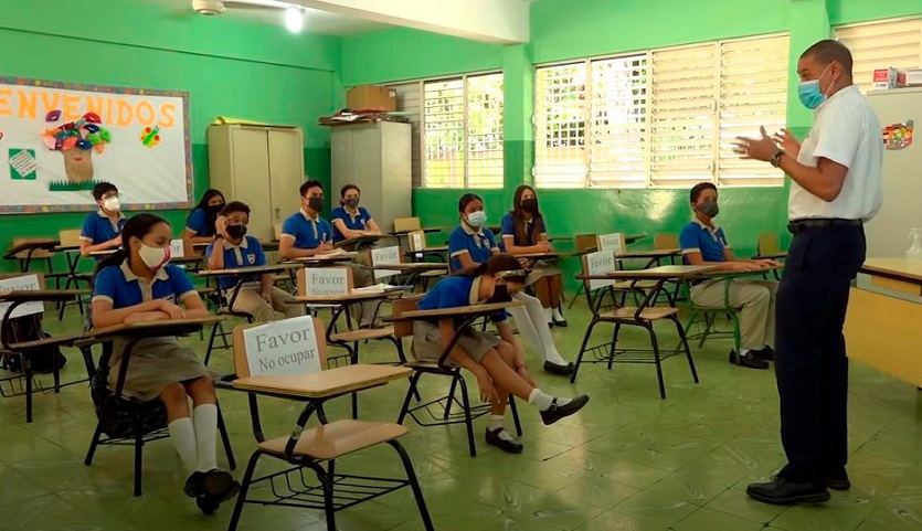 Estudiantes dominicanos toman clases en aulas durante pandemia.