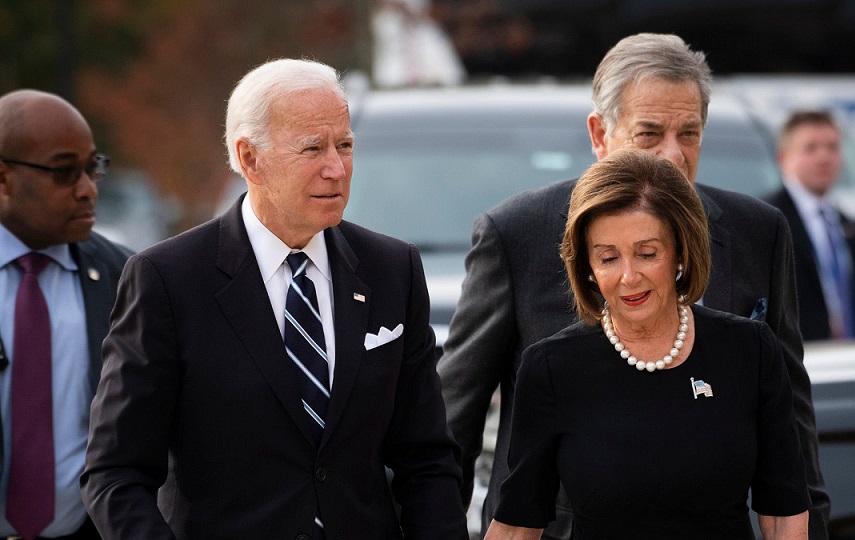 Joe Biden y Nancy Pelosi caminan juntos.