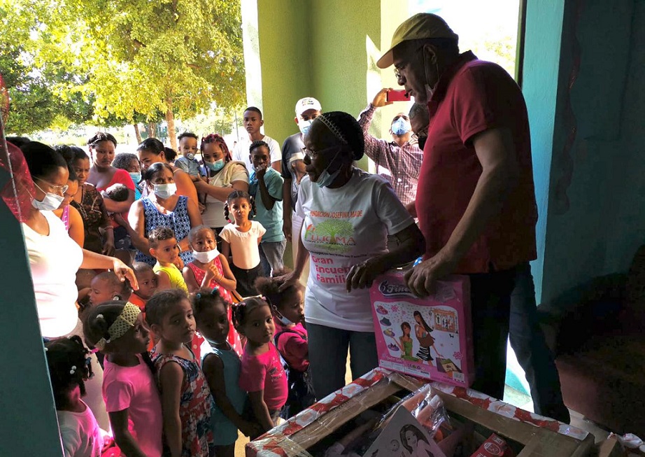 Luis Acosta Moreta entrega juguetes a niños.